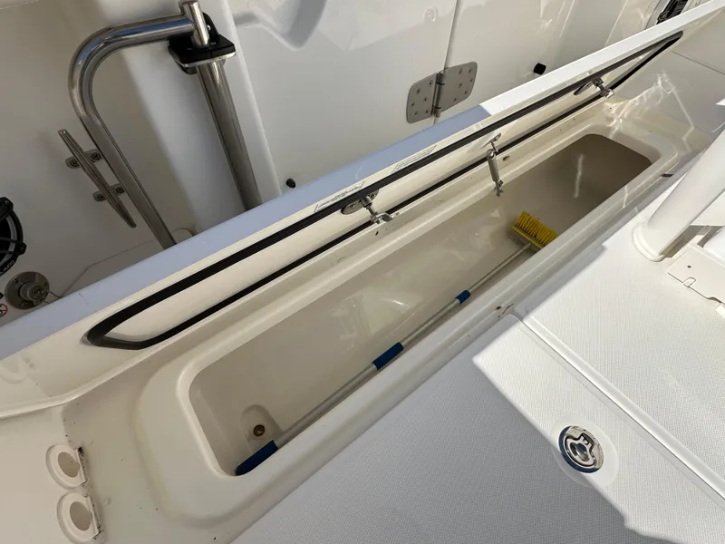 Slide: The Image of 2023 Boston Whaler 280 Outrage storage compartment with cleaning tools. - 41