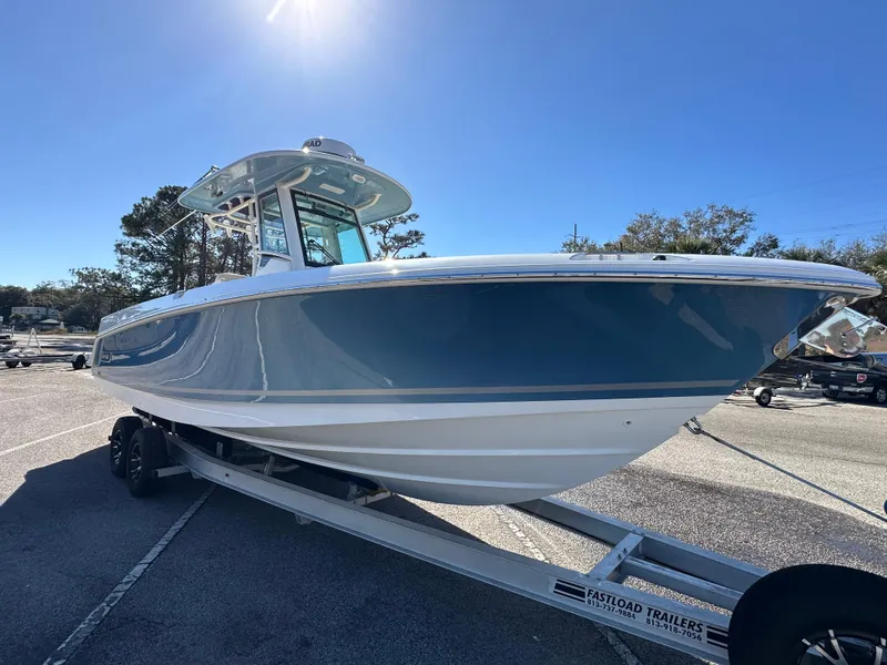 Slide: The Image of 2023 Boston Whaler 280 Outrage boat on trailer under clear blue sky. - 7