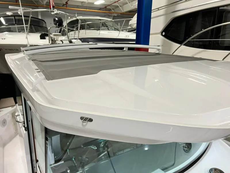 Slide: The Image of 2022 Axopar 28 CABIN boat roof detail in a showroom setting. - 10