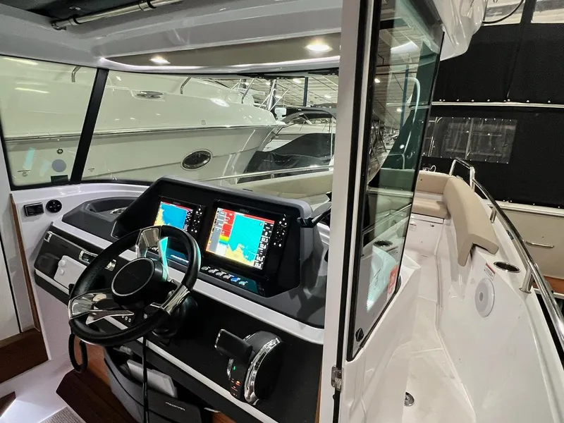 Slide: The Image of 2022 Axopar 28 CABIN boat interior with modern navigation system and steering wheel. - 12