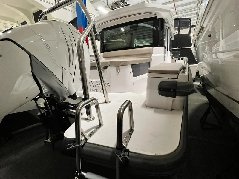 Slide: The Image of 2022 Axopar 28 CABIN boat, rear view, in a showroom with outboard motor. - 2