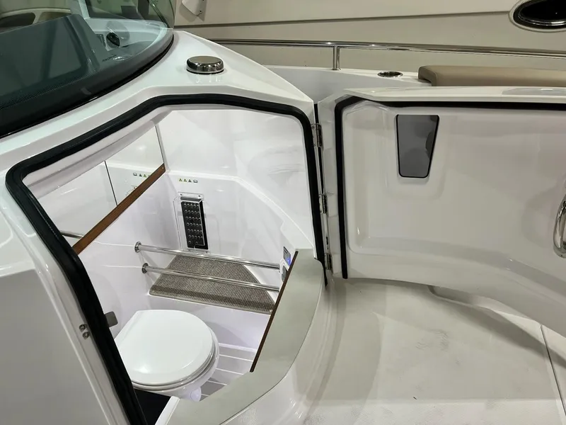 Slide: The Image of Axopar 28 CABIN 2022 boat interior with open door revealing compact bathroom. - 20