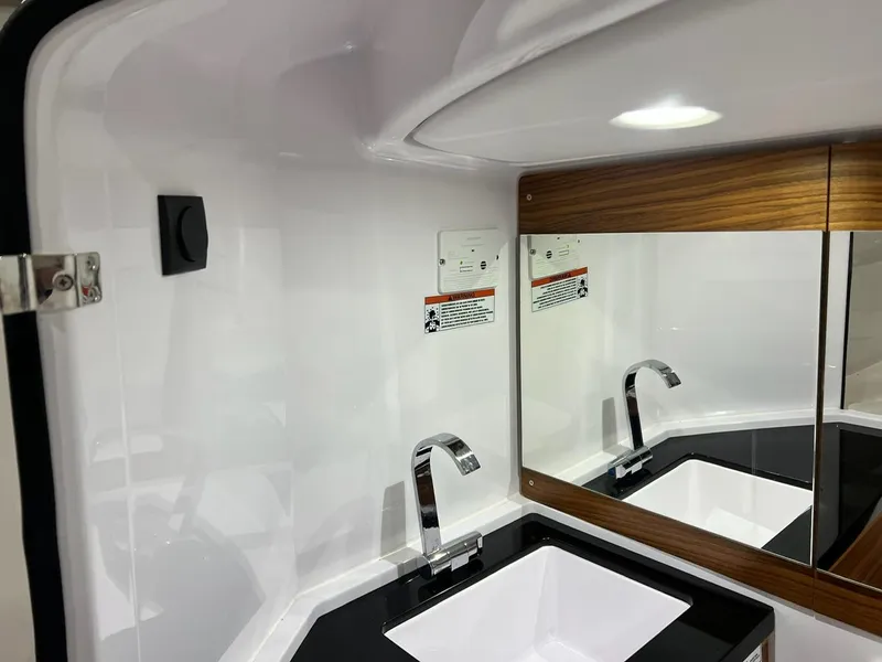 Slide: The Image of Modern bathroom sink in 2022 Axopar 28 CABIN boat, featuring sleek design and mirrored cabinet. - 21