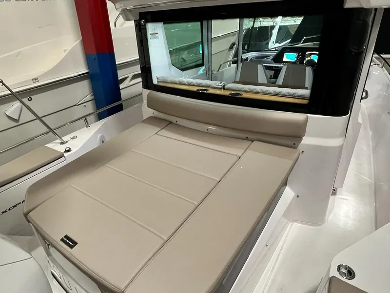 Slide: The Image of 2022 Axopar 28 CABIN boat interior with beige seating and modern dashboard. - 3