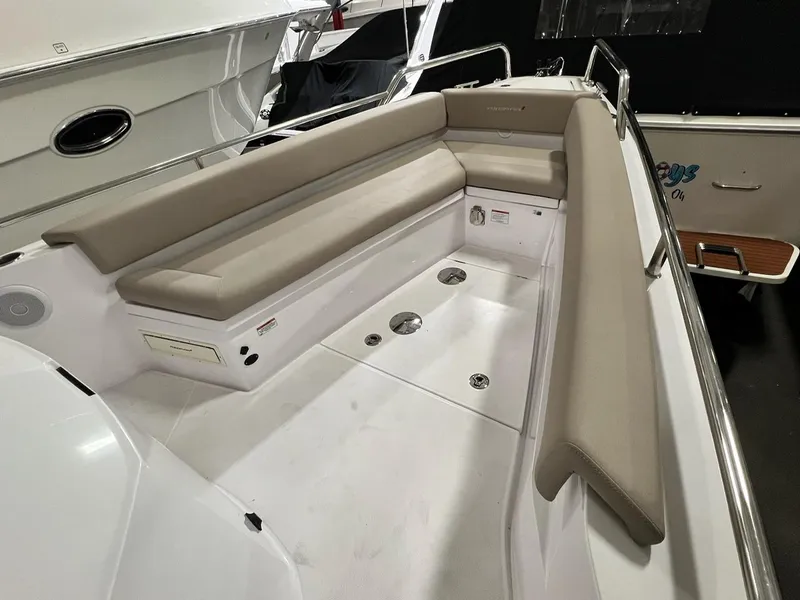 Slide: The Image of 2022 Axopar 28 CABIN boat interior with beige seating and sleek design. - 6