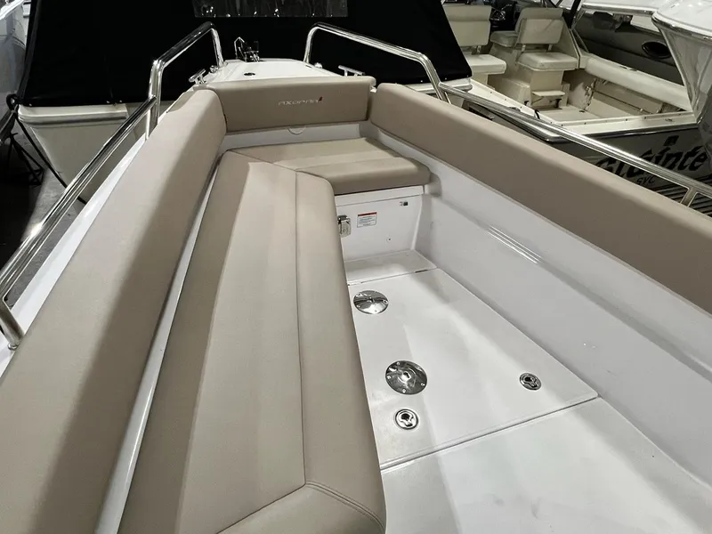 Slide: The Image of 2022 Axopar 28 CABIN boat interior with beige seating and stainless steel fixtures. - 7