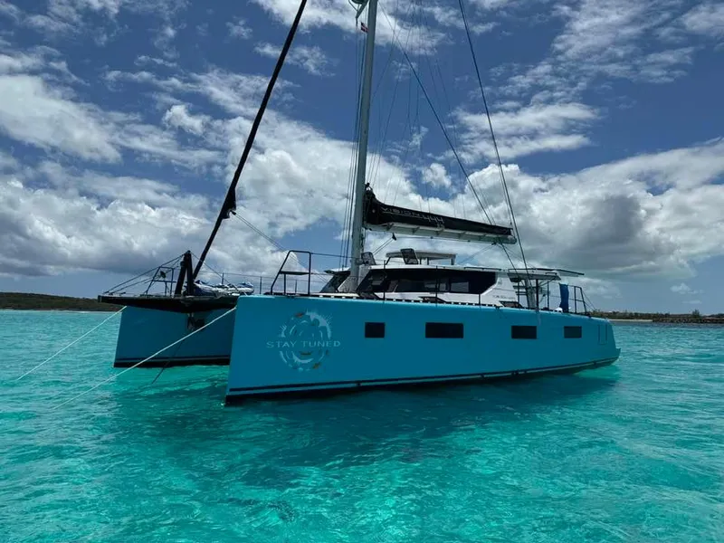 Slide: The Image of Modern Vision 444 catamaran sailing on clear turquoise waters under a partly cloudy sky. - 2