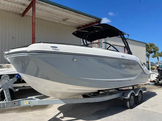 The Image of 2025 Bayliner D22 boat on trailer, parked outdoors under a clear blue sky. - 0