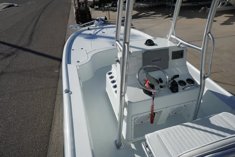 Slide: The Image of 2015 Yellowfin 24 Bay boat interior with console and seating, docked on a sunny day. - 10