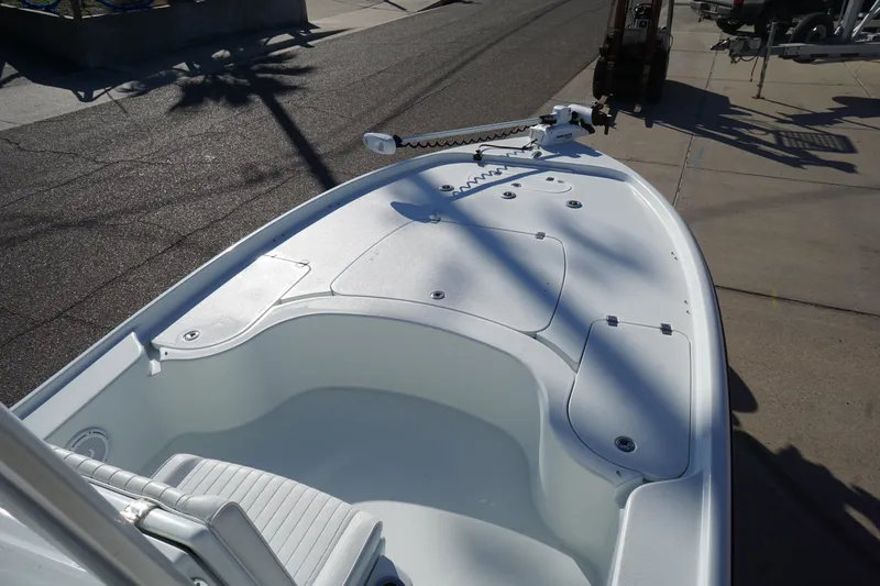 Slide: The Image of 2015 Yellowfin 24 Bay boat deck with trolling motor, parked on a sunny street. - 12