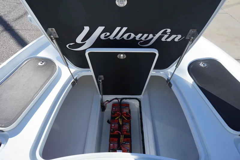 Slide: The Image of 2015 Yellowfin 24 Bay boat storage compartment with batteries visible. - 18