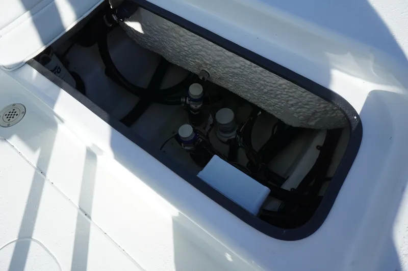 Slide: The Image of 2015 Yellowfin 24 Bay boat storage compartment with visible wiring and components. - 21