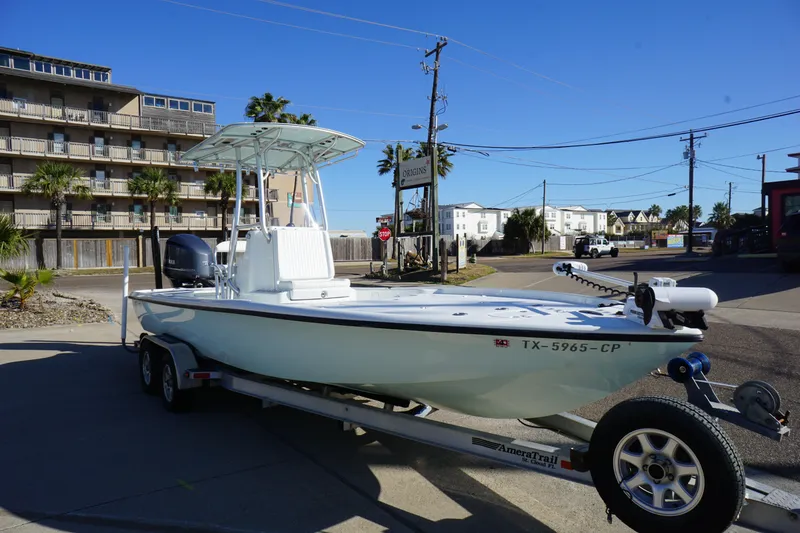Slide: The Image of 2015 Yellowfin 24 Bay boat on trailer, parked in urban area under clear blue sky. - 3