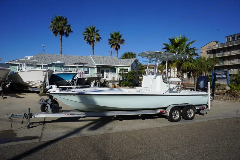 Slide: The Image of 2015 Yellowfin 24 Bay boat on trailer, parked near palm trees and houses. - 4