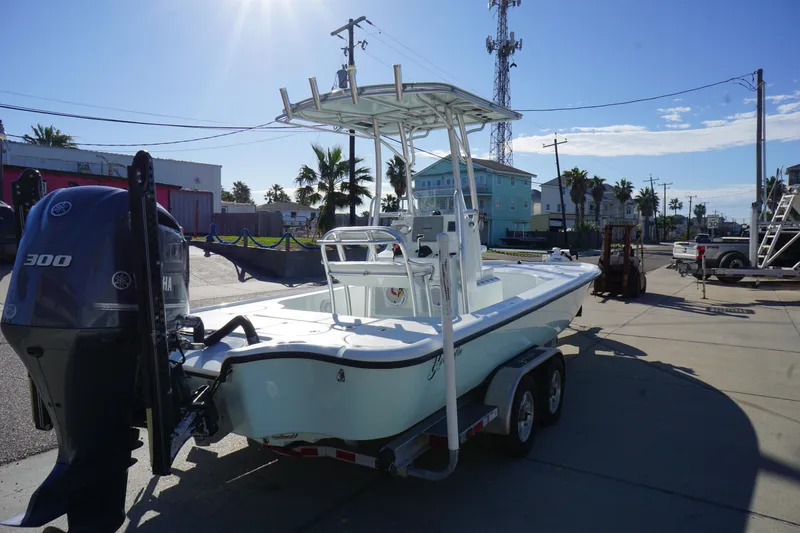 Slide: The Image of 2015 Yellowfin 24 Bay boat on trailer with outboard motor in sunny marina setting. - 6