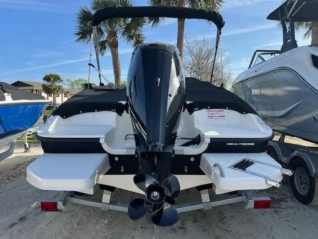 Slide: The Image of 2025 Bayliner Element E16 boat, rear view, on trailer, with outboard motor and black cover. - 2