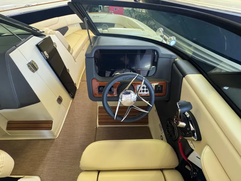 Slide: The Image of 2025 Chris-Craft Sportster 28 interior with modern steering and beige seating. - 18