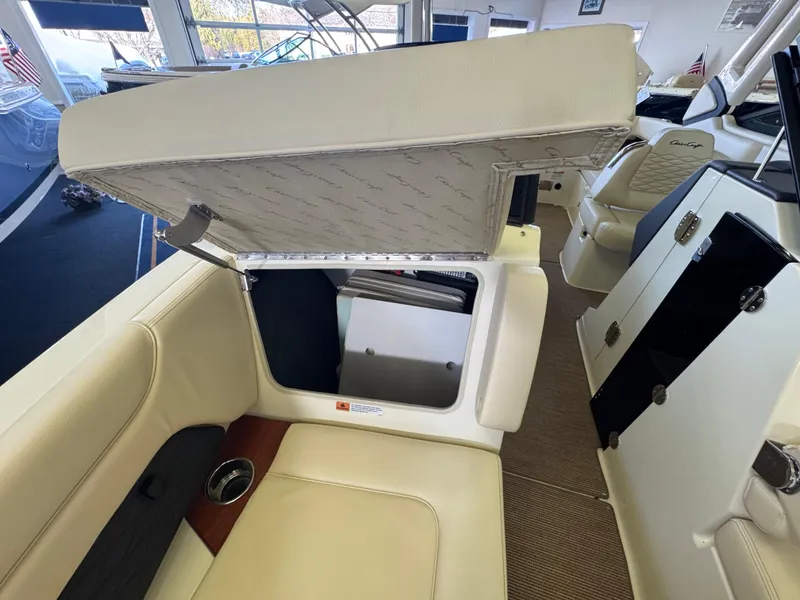 Slide: The Image of 2025 Chris-Craft Sportster 28 interior with open storage compartment and beige seating. - 25
