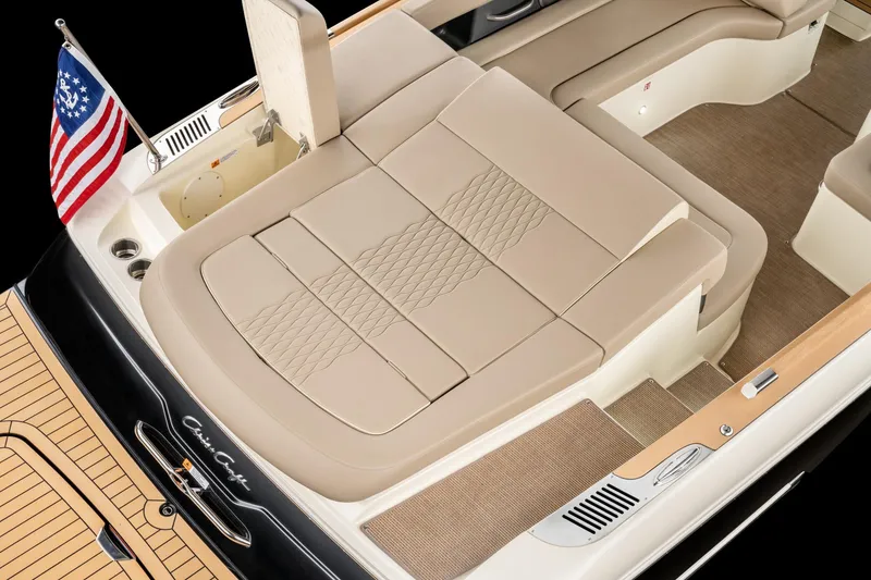 Slide: The Image of 2025 Chris-Craft Sportster 28 boat interior with beige seating and American flag. - 36