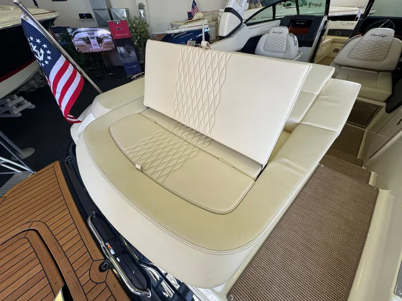 Slide: The Image of 2025 Chris-Craft Sportster 28 boat interior with beige seating and American flag. - 4