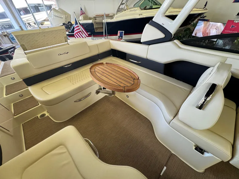 Slide: The Image of 2025 Chris-Craft Sportster 28 interior with beige seating and wooden table. - 8