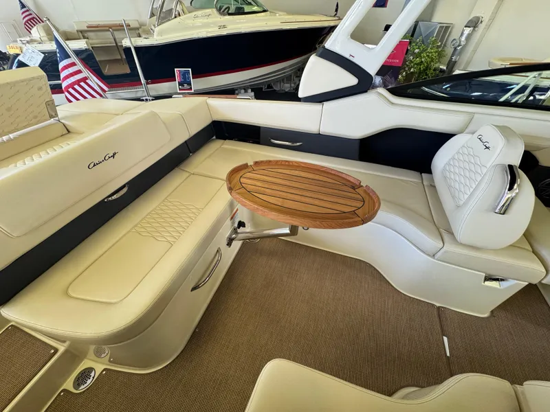 Slide: The Image of 2025 Chris-Craft Sportster 28 interior with beige seating and wooden table. - 9