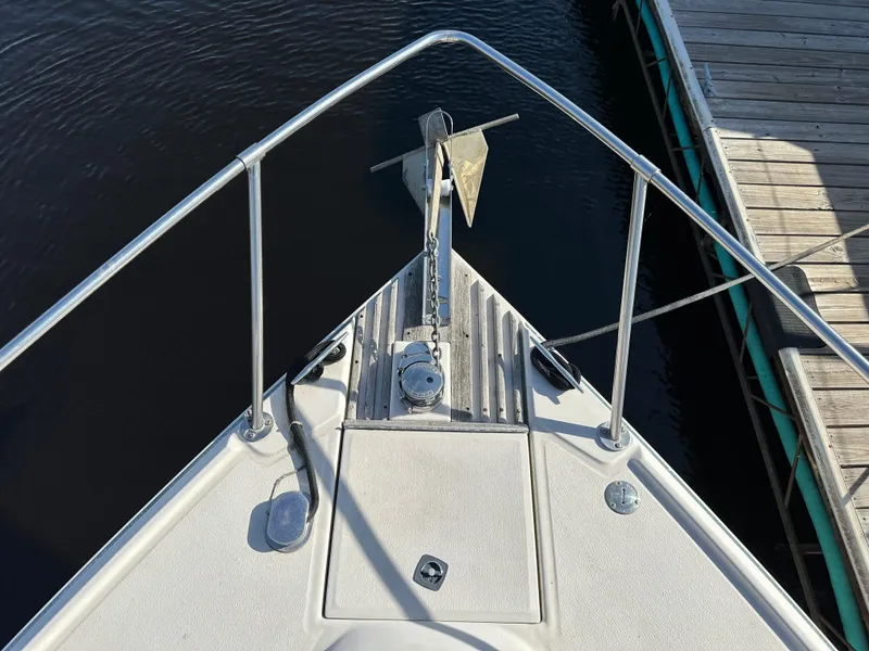 Slide: The Image of 1987 Sea Ray 300 Sedan Bridge bow with anchor and railing, docked at marina. - 11