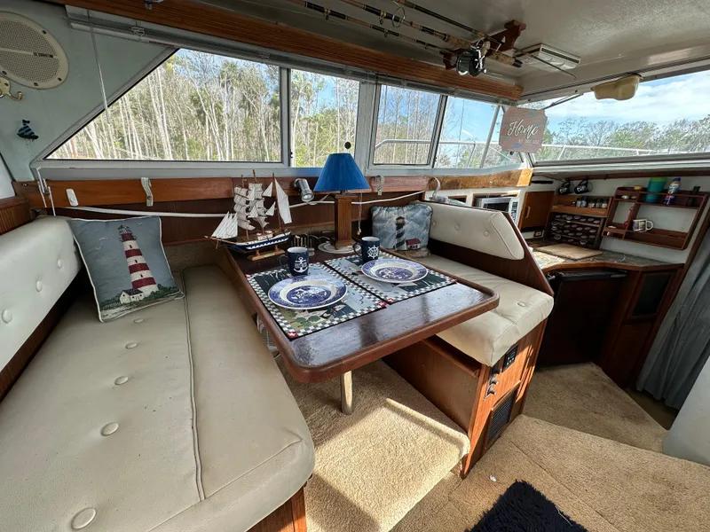 Slide: The Image of Interior of 1987 Sea Ray 300 Sedan Bridge with cozy dining area and nautical decor. - 15