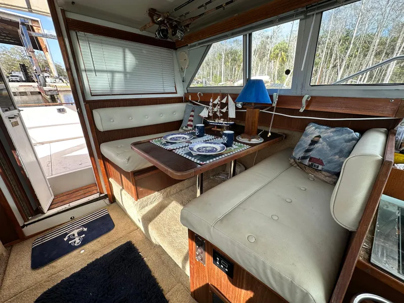 Slide: The Image of Interior of 1987 Sea Ray 300 Sedan Bridge with dining area and nautical decor. - 16