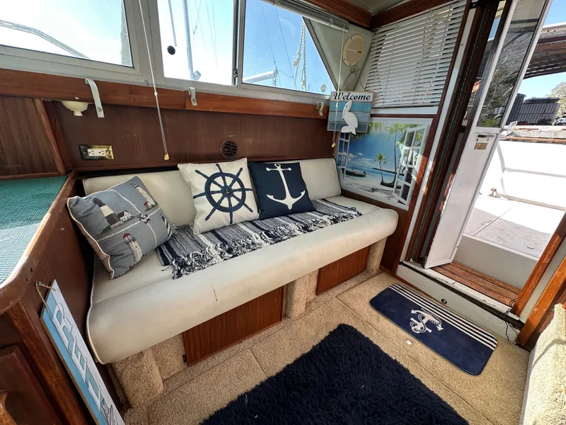 Slide: The Image of 1987 Sea Ray 300 Sedan Bridge interior with nautical-themed decor and cozy seating area. - 17