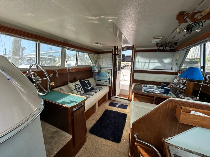 Slide: The Image of 1987 Sea Ray 300 Sedan Bridge interior with helm, seating, and nautical decor. - 19