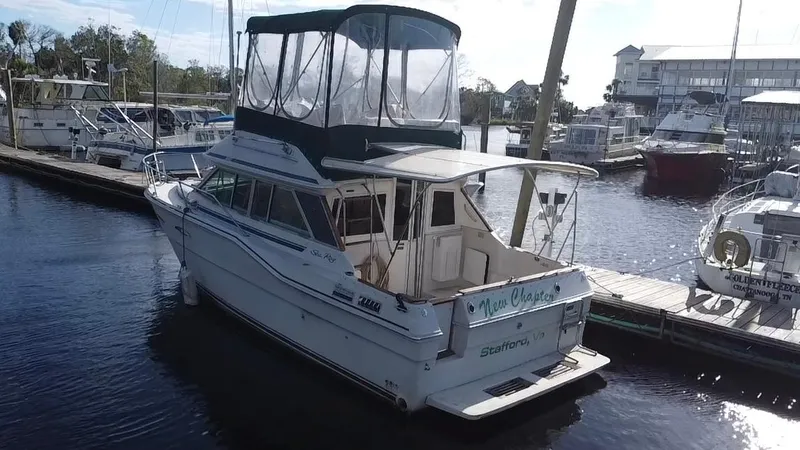 Slide: The Image of 1987 Sea Ray 300 Sedan Bridge docked at marina, featuring spacious upper deck and cabin. - 2