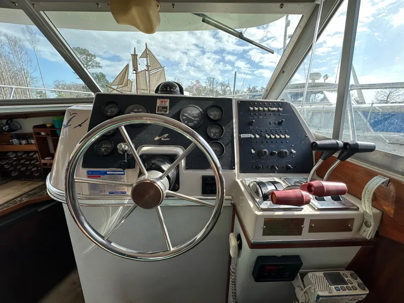 Slide: The Image of 1987 Sea Ray 300 Sedan Bridge helm with steering wheel and control panel. - 20