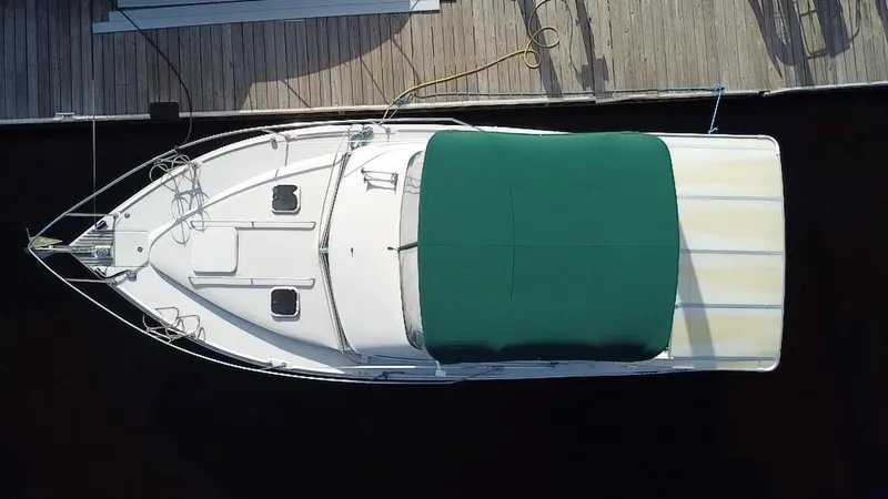 Slide: The Image of 1987 Sea Ray 300 Sedan Bridge boat docked, aerial view with green canopy. - 3