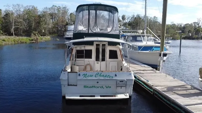 Slide: The Image of 1987 Sea Ray 300 Sedan Bridge docked, rear view, with "New Chapter" name, Stafford, VA. - 4