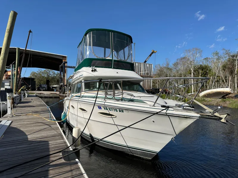 Slide: The Image of 1987 Sea Ray 300 Sedan Bridge docked at marina under clear blue sky. - 6