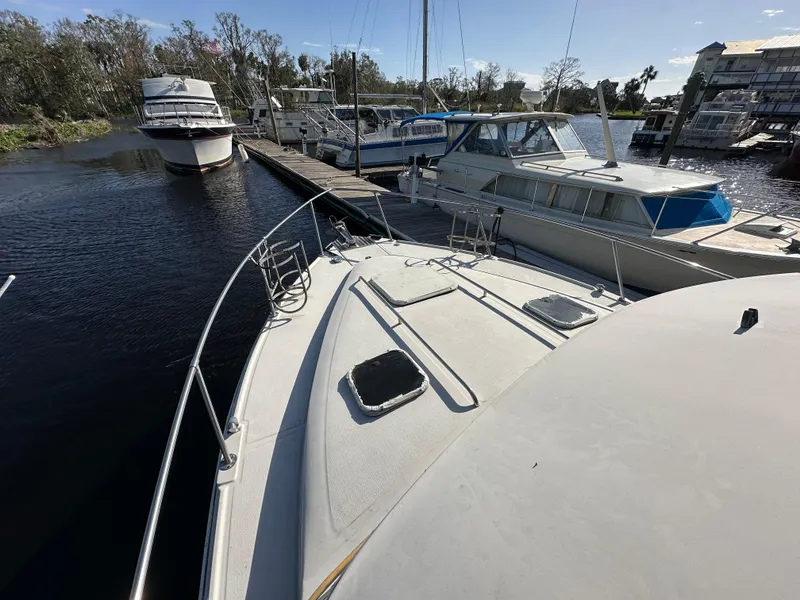 Slide: The Image of 1987 Sea Ray 300 Sedan Bridge docked at marina with other boats. - 8