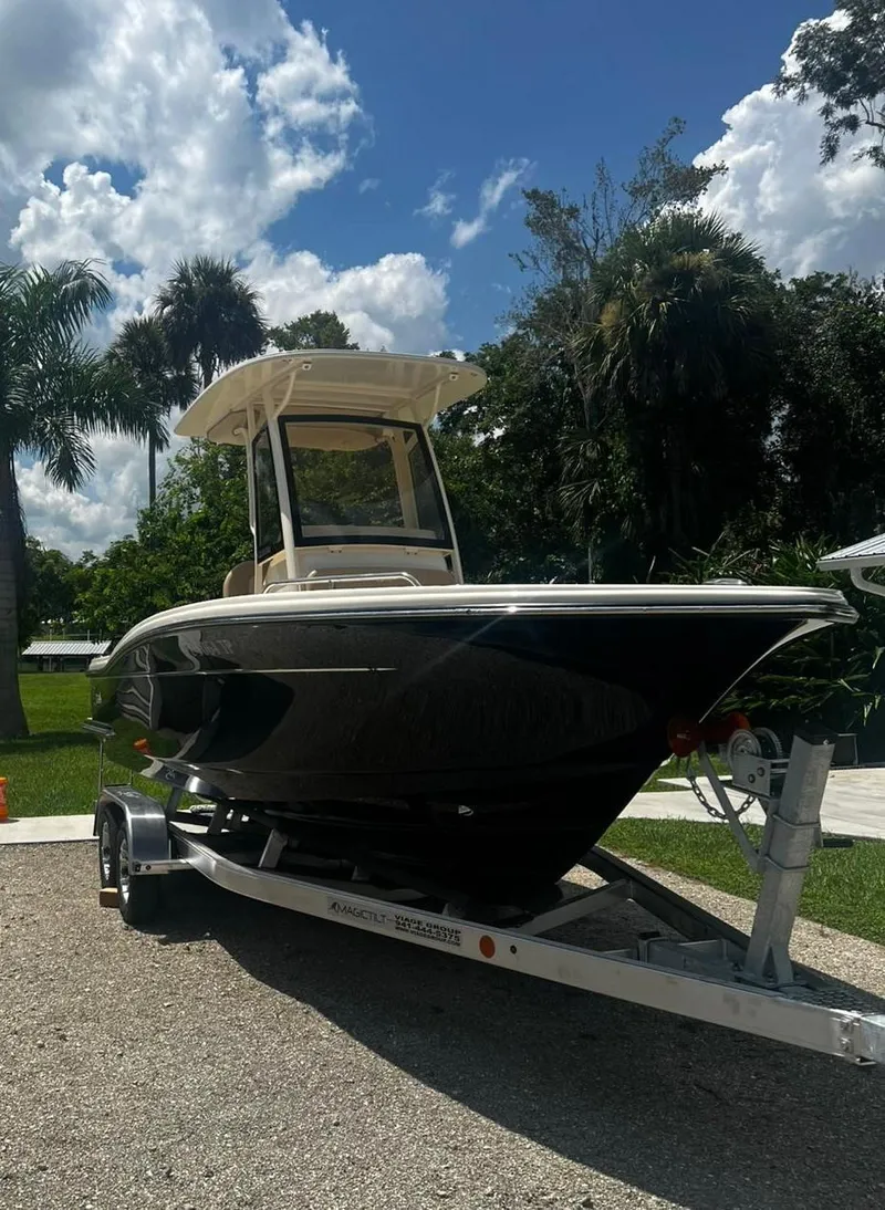 Slide: The Image of 2024 Scout 215 XSF boat on trailer, surrounded by trees and blue sky. - 5