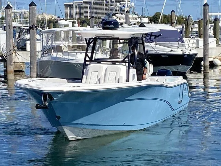 Slide: The Image of 2022 Sea Fox 328 Commander boat docked in marina, featuring sleek blue design. - 1
