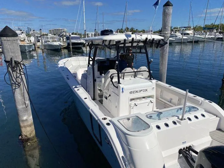 Slide: The Image of 2022 Sea Fox 328 Commander docked at marina, clear blue sky, calm water. - 10