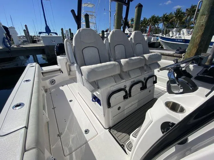 Slide: The Image of 2022 Sea Fox 328 Commander boat interior with plush seating at marina dock. - 17