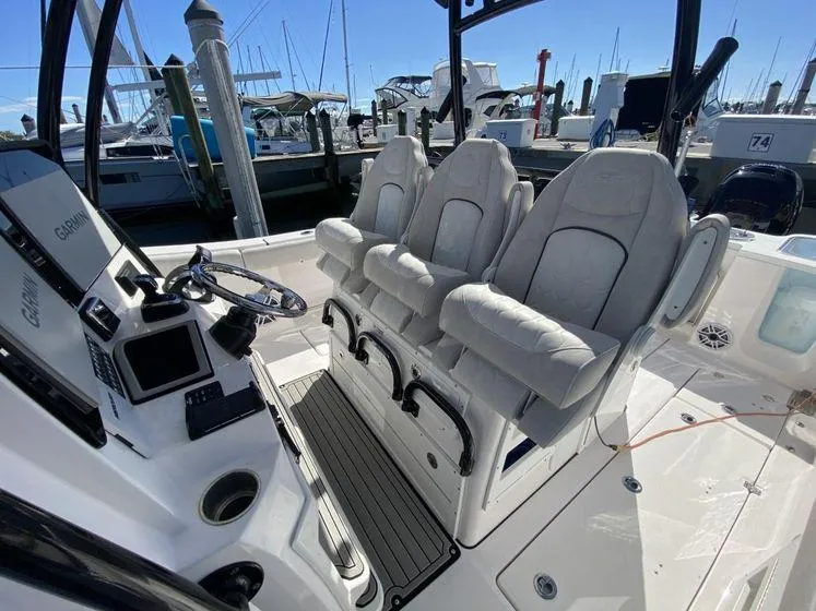 Slide: The Image of 2022 Sea Fox 328 Commander boat interior with three cushioned seats and control panel. - 19