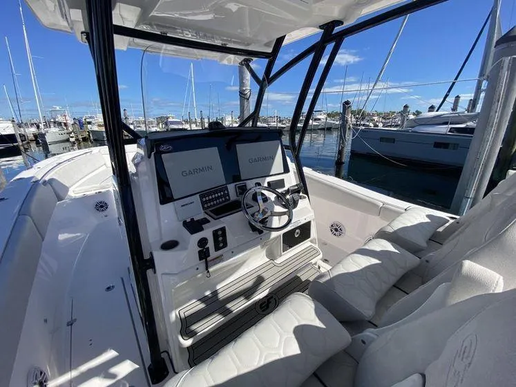 Slide: The Image of 2022 Sea Fox 328 Commander boat cockpit with Garmin displays, docked at marina. - 24