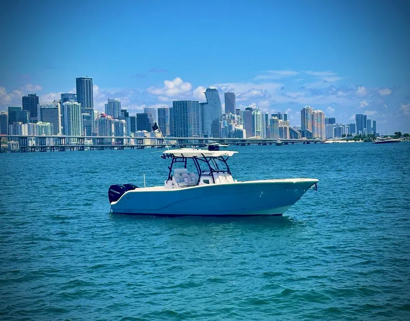 Slide: The Image of 2022 Sea Fox 328 Commander boat on water with city skyline backdrop. - 4