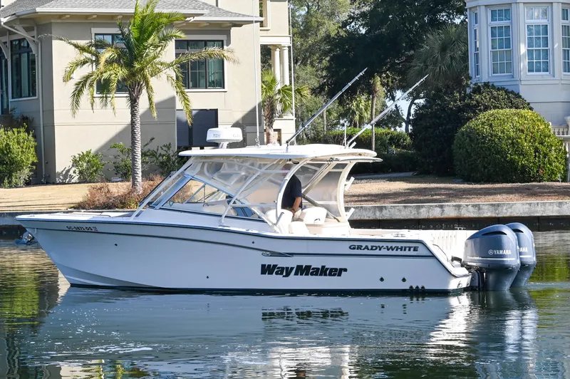 Slide: The Image of 2014 Grady-White Freedom 307 boat docked near waterfront homes. - 11
