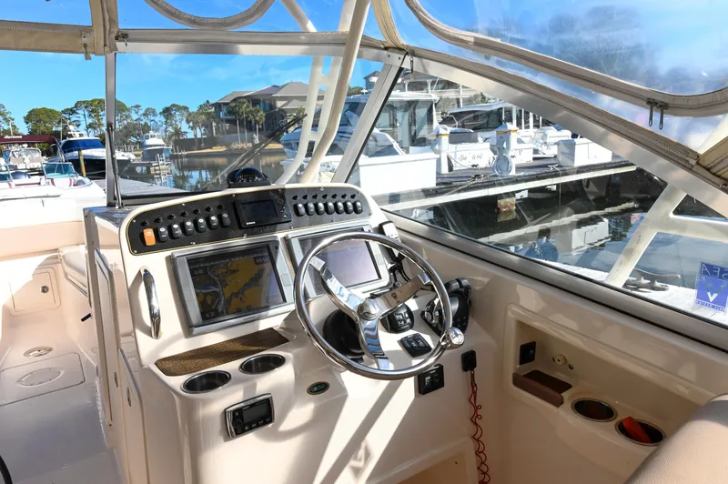 Slide: The Image of 2014 Grady-White Freedom 307 boat dashboard with navigation controls and steering wheel. - 15