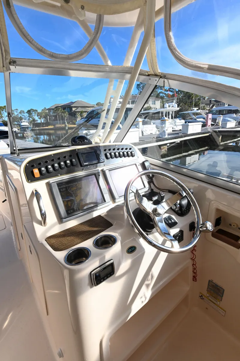 Slide: The Image of 2014 Grady-White Freedom 307 boat helm with steering wheel and navigation controls. - 16