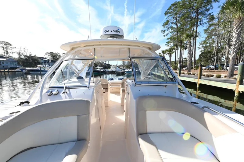 Slide: The Image of 2014 Grady-White Freedom 307 boat docked, featuring spacious seating and Garmin equipment. - 18
