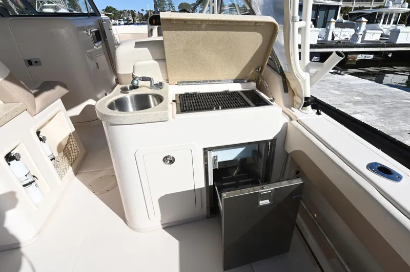 Slide: The Image of 2014 Grady-White Freedom 307 boat interior with sink, grill, and mini fridge. - 27