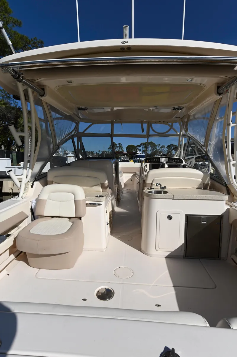 Slide: The Image of 2014 Grady-White Freedom 307 boat interior with seating and helm, under clear blue sky. - 30